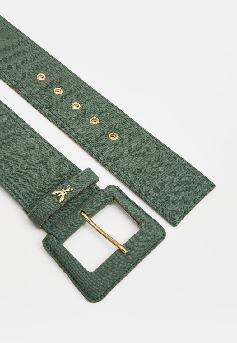 Grüner Stoffgürtel mit einer quadratischen goldenen Schnalle, fünf verstellbaren Löchern und einem dekorativen Metalldetails in der Nähe der Schnalle. Glatte Textur.