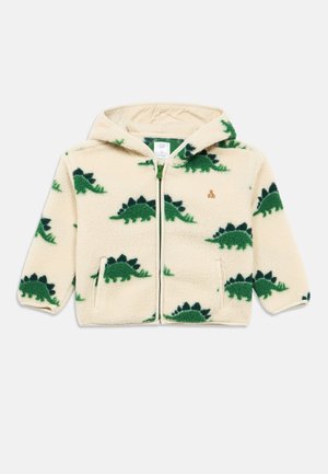 Flis jopica z zadrgo v krem barvi z zelenim vzorcem dinozavra. Ima podložen kapuco in stranske žepke. Mehka tekstura, priložnostna zasnova.