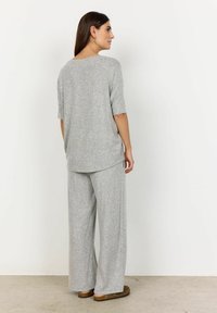Svetlošedý mäkký loungewear set pozostávajúci z voľného trička s krátkymi rukávmi a nohavíc s širokými nohavicami. Minimalistický dizajn bez vzorov.