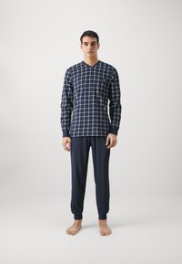 Navy-blaues Loungewear-Set mit Karomuster, bestehend aus einem V-Ausschnitt Langarm-Oberteil und passenden, umgekrempelten Hosen, hergestellt aus weichem, leichtem Stoff.