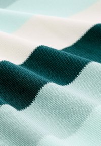 Textil mit abwechselnden Streifen in Blaugrün, Minzgrün und Creme. Glatte Textur mit gewebtem Muster und weicher Oberfläche.