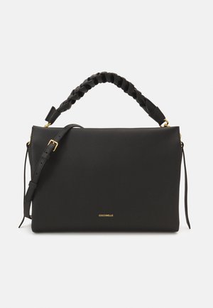 Sac à main en cuir noir avec une finition texturée, doté d'une anse tressée en haut et d'une bandoulière amovible. Accent logo doré visible.