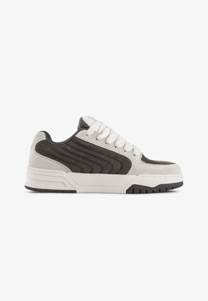 Shoe cinza e branco com parte superior em camurça e têxtil, sola grossa, bico redondo e acabamentos texturizados nas laterais. Cadarços em branco contrastante.