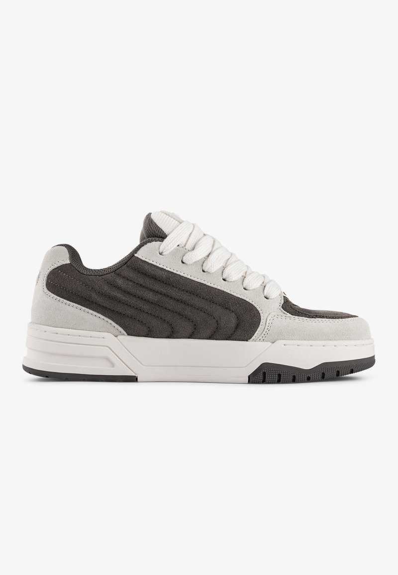 Szürke és fehér sneaker, velúr és textil felsőrésszel, vastag talppal, kerek orral és textúrázott oldalelemekkel. A fűzője kontrasztos fehér színű.