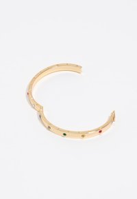 Pulsera de brazalete de oro con un acabado suave, que presenta piedras coloridas y letras grabadas en la superficie. Diseño abierto para facilitar su uso.