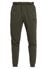 Olivgröna Nike-joggingsbyxor av mjukt material, med resårmidja, sidfickor och en svart logotyp på övre vänstra benet.