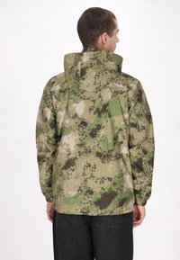 Camouflagejas met een mix van groen, beige en donkerbruin. Het heeft een capuchon en elastische manchetten. Het materiaal lijkt duurzaam en soepel.