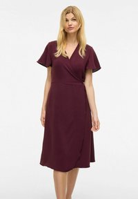 Vestido cruzado burdeos con mangas cortas y acampanadas, dobladillo a la altura de la rodilla, tejido texturizado y una corbata lateral para un ajuste ajustable.