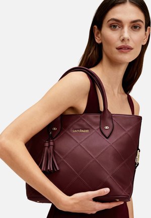 Borsa tote color granato in pelle trapuntata, caratterizzata da un dettaglio con nappina, due manici e logo dorato. Forma rettangolare con motivo cucito.