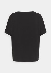 Black short-sleeve top with a straight cut, round neckline, and folded sleeves. Smooth texture with side slits at the hem.