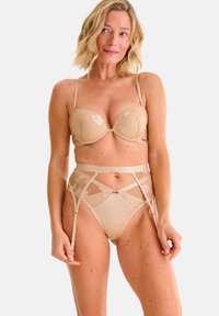 Set di lingerie beige composto da un reggiseno leggermente imbottito con ricami floreali e una cinta alta con gancetti caratterizzata da pannelli trasparenti e spalline regolabili.