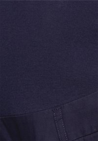 Tecido azul-marinho com textura estriada, apresentando uma transição suave para uma seção lisa na parte inferior. Sem padrões ou hardware visíveis.