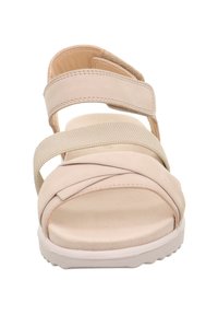 Beige Sandale mit überkreuzten Elastikbändern, weichem Obermaterial und strukturiertem Fußbett. Verfügt über eine weiße Gummisohle für guten Halt.