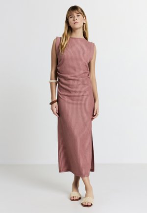 Langes, geripptes Kleid in Farbe Staubrosa mit gerader Silhouette, ärmellosem Design und Seitenschlitz. Kombiniert mit beigen strukturierten Sandalen.