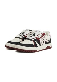 Un paio di sneakers basse con pannelli bianchi, neri e bordeaux, lacci bianchi e un grande logo "A/X" sul lato.