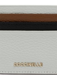 Portafoglio bianco in pelle con accenti marroni, neri e dorati. Presenta una superficie testurizzata e un logo impresso. Forma rettangolare con linee pulite.