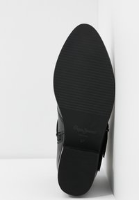 Černá kožená bota s texturovanou podrážkou, zaoblenou špičkou a bočními akcenty. Velikost 37 je uvedena na podrážce.