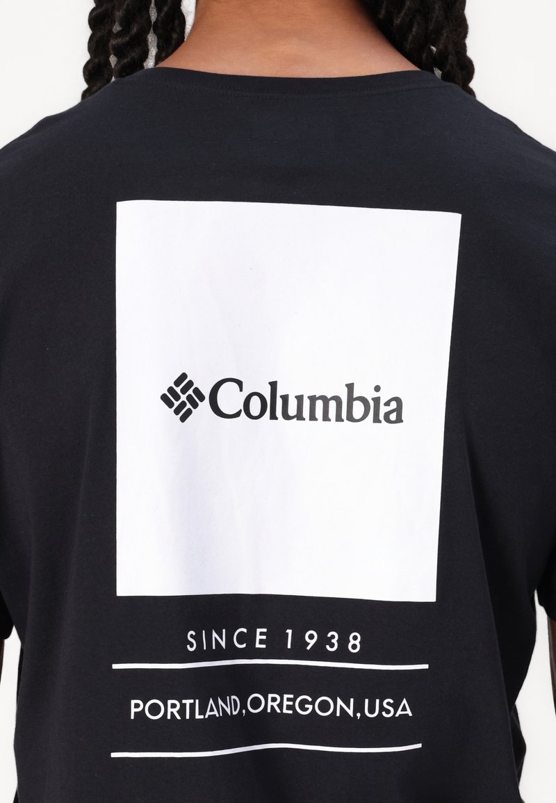 T-shirt en coton noir arborant un graphique rectangulaire blanc avec le logo "Columbia" et le texte « Depuis 1938, Portland, Oregon, USA » centré en dessous.