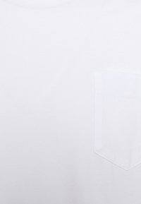 T-shirt bianco in cotone con scollatura a V e taschino sul petto. Tessuto liscio senza motivi o design visibili.