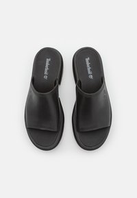 Infradito neri in pelle liscia con design a fascia ampia. Presentano una soletta imbottita e il logo Timberland sulla soletta.