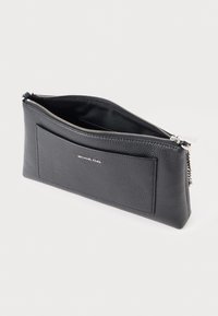 Sort pebret læder clutch med sølv lynlås, udvendig lomme og Michael Kors logo på fronten mod hvid baggrund.