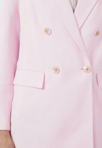 Roze dubbelgeknoopte blazer van gladde stof, met twee grote knopen, spitse revers en zijzakken. Minimalistische ontwerpdetails.