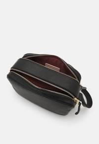 Borsa in pelle nera con finitura testurizzata, dotata di due cerniere dorate, un interno bordeaux e una maniglia laterale per un facile trasporto.