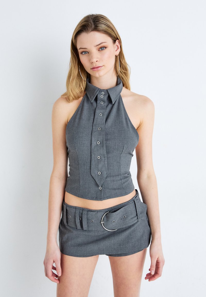 Hallkriipsuga hall crop top, millel on terav krae ja nupupaneel, ning sobiv mini seelik, millel on lai vöö ja ümmargune pandla.