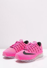 Chaussures de sport Nike, tige textile rose vif, accents noirs, design en maille et semelle en caoutchouc transparente avec amorti.