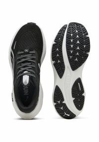 Scarpe da ginnastica nere realizzate in mesh traspirante con dettagli riflettenti, dotate di una suola bianca testurizzata e di un battistrada in gomma a motivo.