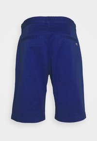 Námořnické modré šortky s pásem, dvěma zadními kapsami a malým logem na levé straně. Látka má hladkou, lehkou strukturu.