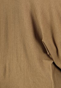 Bruin gebreid stof met een gladde textuur, voorzien van een lichte glans en een verticale ribbelpatroon, die zachtjes valt.