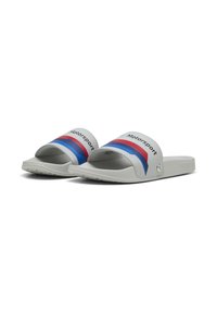Sandales de plage gris clair avec une large sangle ornée de rayures rouges et bleues et le texte "Motorsport". Semelles texturées pour une meilleure adhérence.