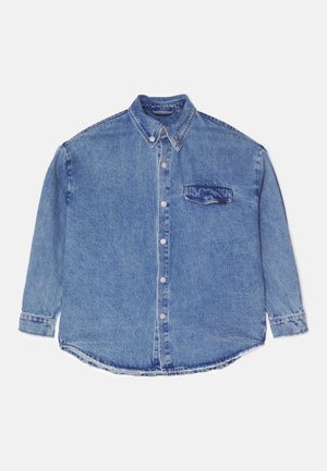 Light blue denim shirt with long sleeves, button-up front, pointed collar, and a single patch pocket on the left chest. Distressed hem details.