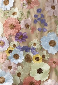 Brocade blomstermønster med forskellige farver, herunder pink, blå, gul og lilla på en beige baggrund, med detaljerede teksturer.