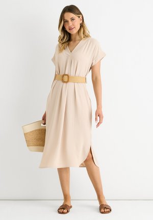 Abito beige a lunghezza ginocchio con scollatura a V e maniche corte, cinlciato in vita con una cintura texturizzata color testa di moro; abbinato a sandali marroni e una borsa intrecciata.