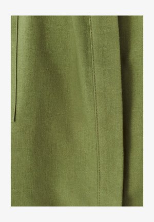 Olijfgroene stof met een gladde textuur, met een naaddetail aan één kant. Het materiaal lijkt lichtgewicht en ademend.