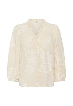 Blouse crème à manches longues avec col en V à volants et broderie florale blanche, dotée de poignets froncés et d'épaules bouffantes.