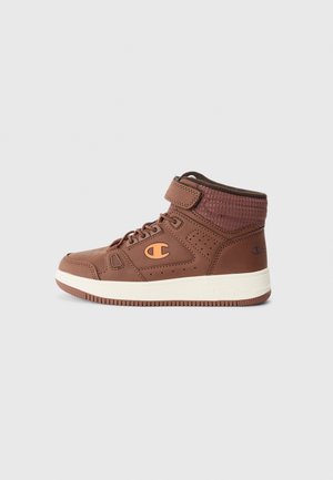 Zapatilla alta de cuero marrón con detalles perforados, suela de goma, correa ajustable y logotipo naranja en contraste en el costado.