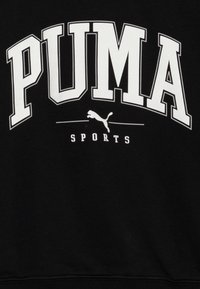 Crna dukserica s velikim bijelim PUMA logotipom i natpisom "SPORTS". Glatka tekstura s ojačanim manžetama i donjim rubom. Standardni kroj.