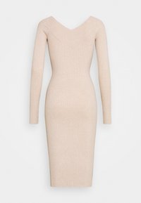 Robe moulante beige en tricot avec des manches longues, décolleté en V et texture côtelée, présentant une silhouette ajustée et une longueur au genou.