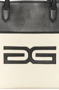 Velika torba za nošenje s crnim kožnim vrhom i tijelom od krem platna, ukrašena istaknutim reljefnim crnim logotipom na prednjoj strani.