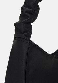 Sac à main en satin noir avec une bandoulière froncée, une texture lisse et une forme structurée au design minimaliste. Aucune quincaillerie ou accent visible.