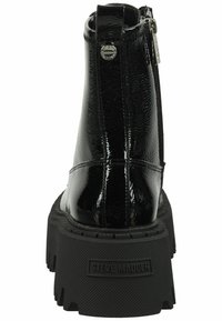Stivali alla caviglia in pelle verniciata nera con suola in gomma spessa. Presentano una cerniera laterale e un piccolo pannello con logo sul retro. Finitura testurizzata.