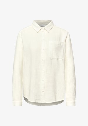 Valkoinen pitkähihainen kauluspaita, jossa on rintatasku ja teksturoidusta kankaasta valmistettu klassinen kaulus sekä kaartuva helma.