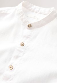 Chemise en lin blanc avec col indien et trois boutons beige sur le devant, fabriquée par NEXT.