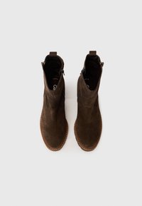 Hnědé semišové kotníkové boty s hladkou texturou, bočním zipem a prošitou světle hnědou podrážkou. Design má minimalistický a moderní tvar.