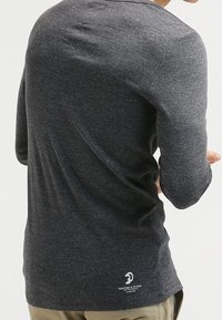 Herr långärmad t-shirt i mörk heathergrå, i en bomullsblandning, har en rundad nederkant och en liten logotyp på baksidan nära midjan.