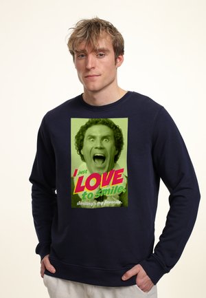 Granatowy sweter z dużą grafiką uśmiechniętej twarzy oraz tekstem w wyrazistych kolorach: zielone tło, różowe i białe litery, okrągły dekolt.