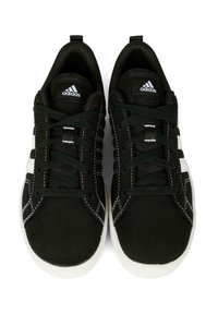 Baskets en toile noire avec semelles en caoutchouc blanches. Comprennent des bandes blanches, des coutures contrastantes et des lacets noirs sur la tige.